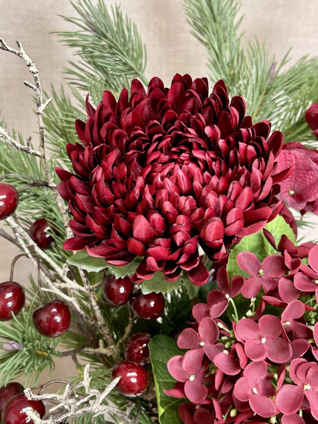 Nærbillede af bordeaux chrysanthemum i buket med kirsebær og hortensia