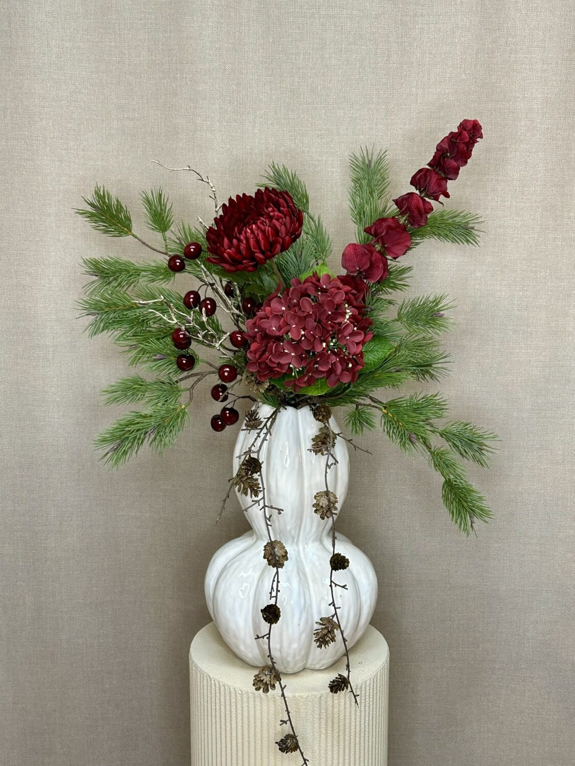 Kirsebærgren stylet i julebuket med fyrregrene, chrysanthemum og hortensia i hvid vase
