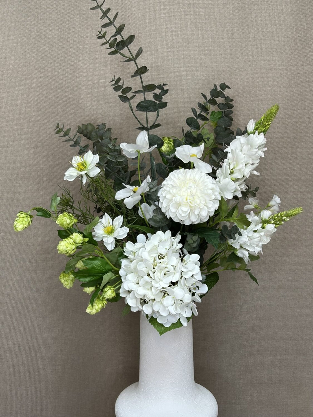 Kunstig hvid dahlia brugt i dekorativ vase med kunstige blomster og grene