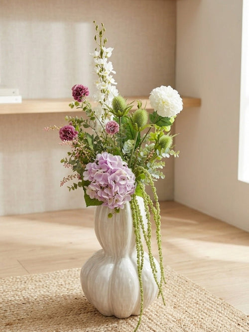 Kunstig eucalyptus gren stylet i vase med blomster