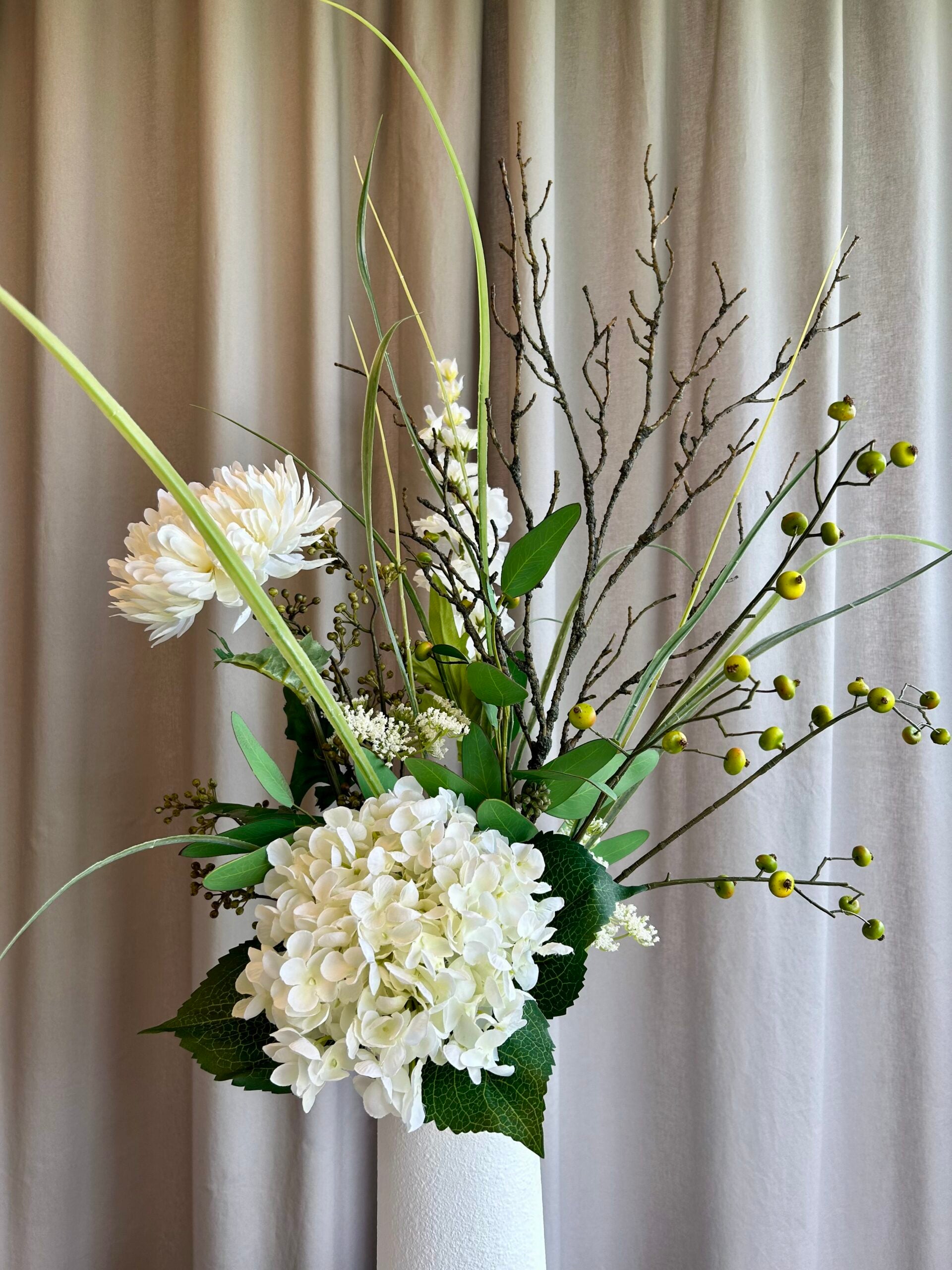 Kunstig hvid hortensia brugt i dekorativ vase med kunstige grene