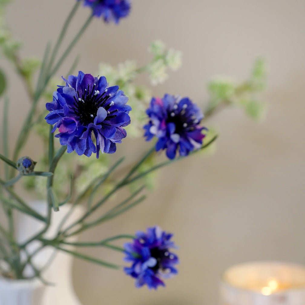 Nærbillede af kunstig blå kornblomst buket med fine blomsterhoveder