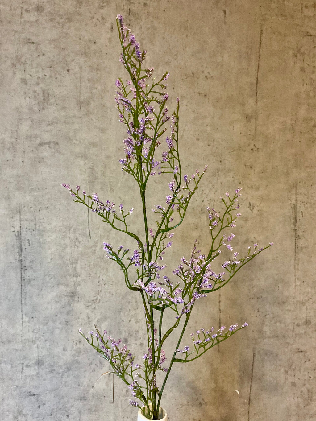 Nærbillede af kunstig limonium gren i lys lilla med fine små blomster