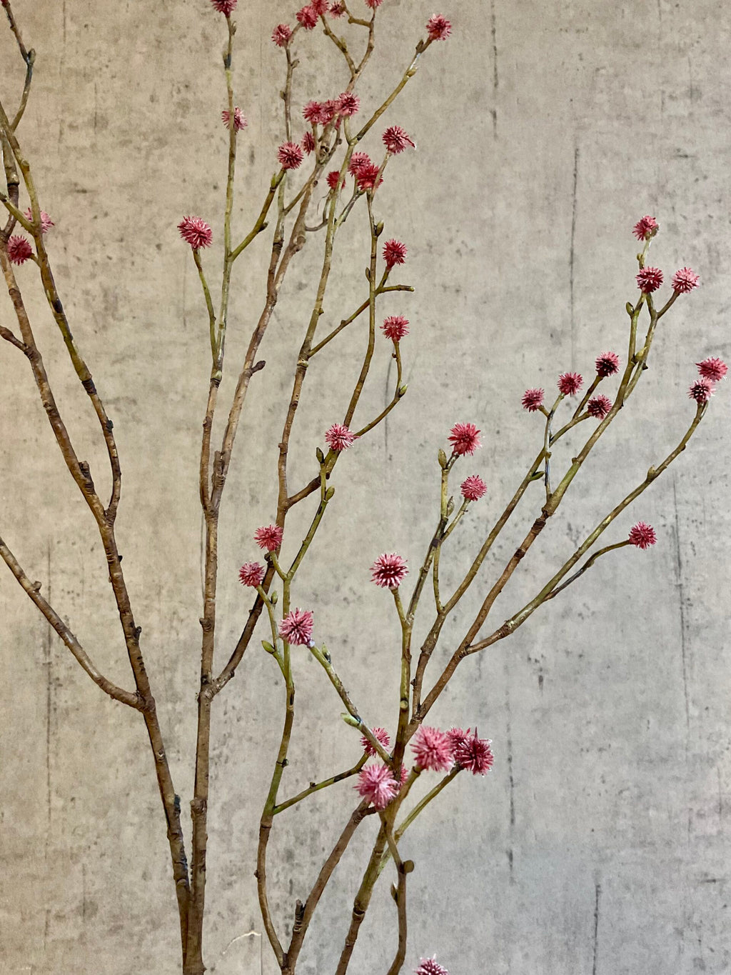 Nærbillede af kunstig mandstro gren med rosa detaljer