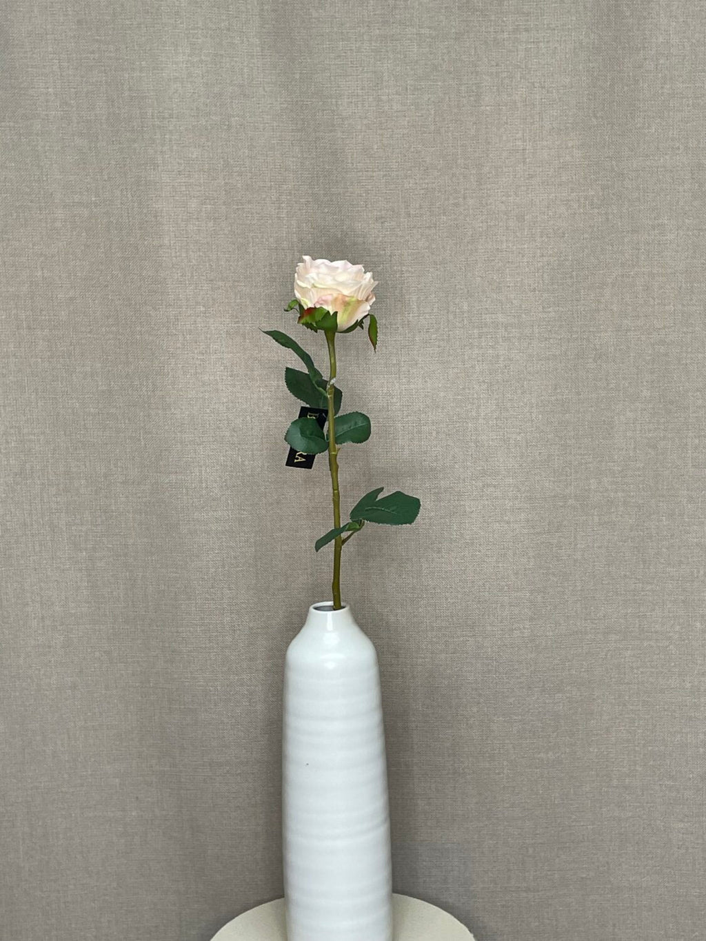 Kunstig cremefarvet rose som enkelt stilk i hvid vase