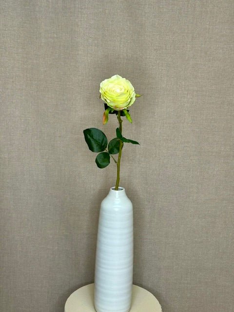 Kunstig limefarvet rose som enkelt stilk i hvid vase