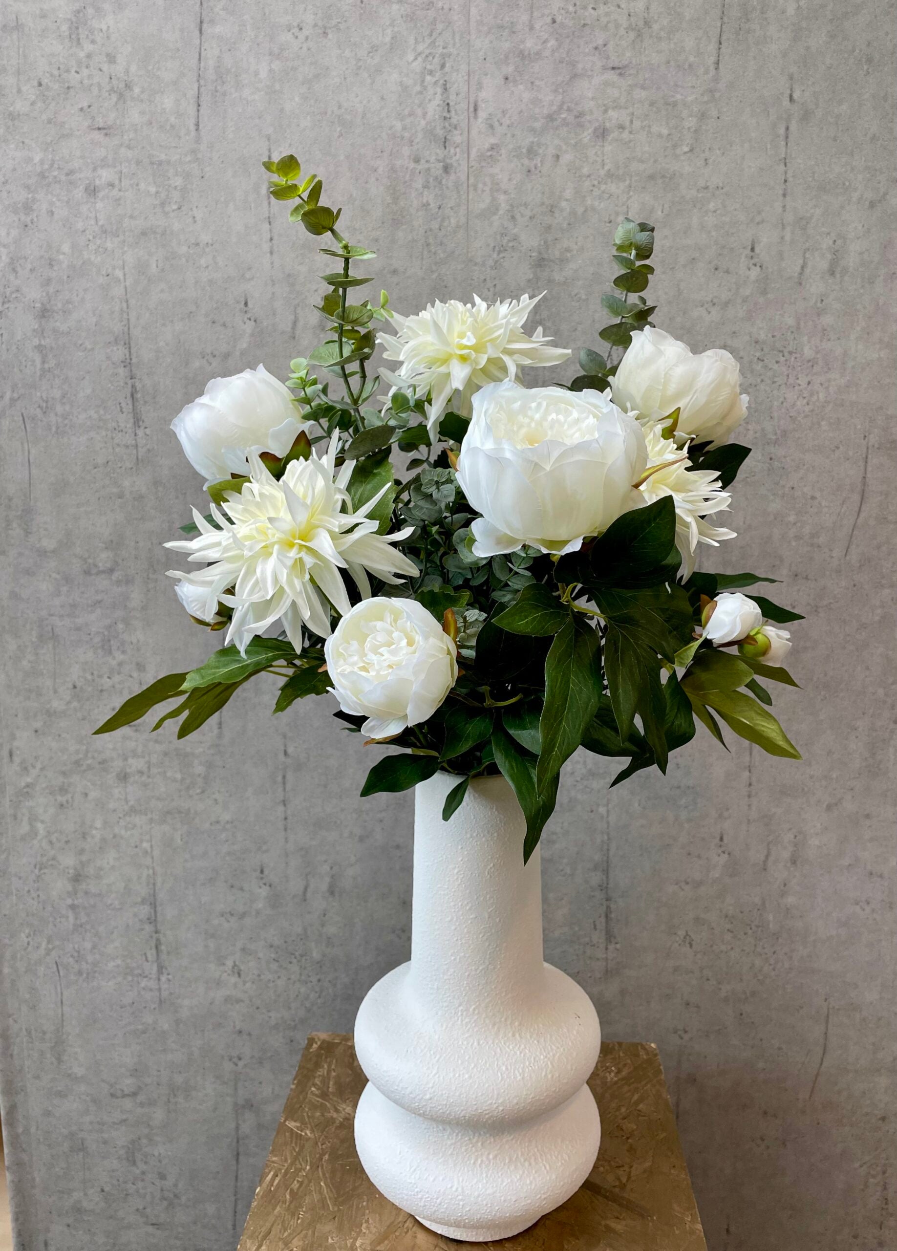 Buket med hvide kunstige peony blomster i hvid vase