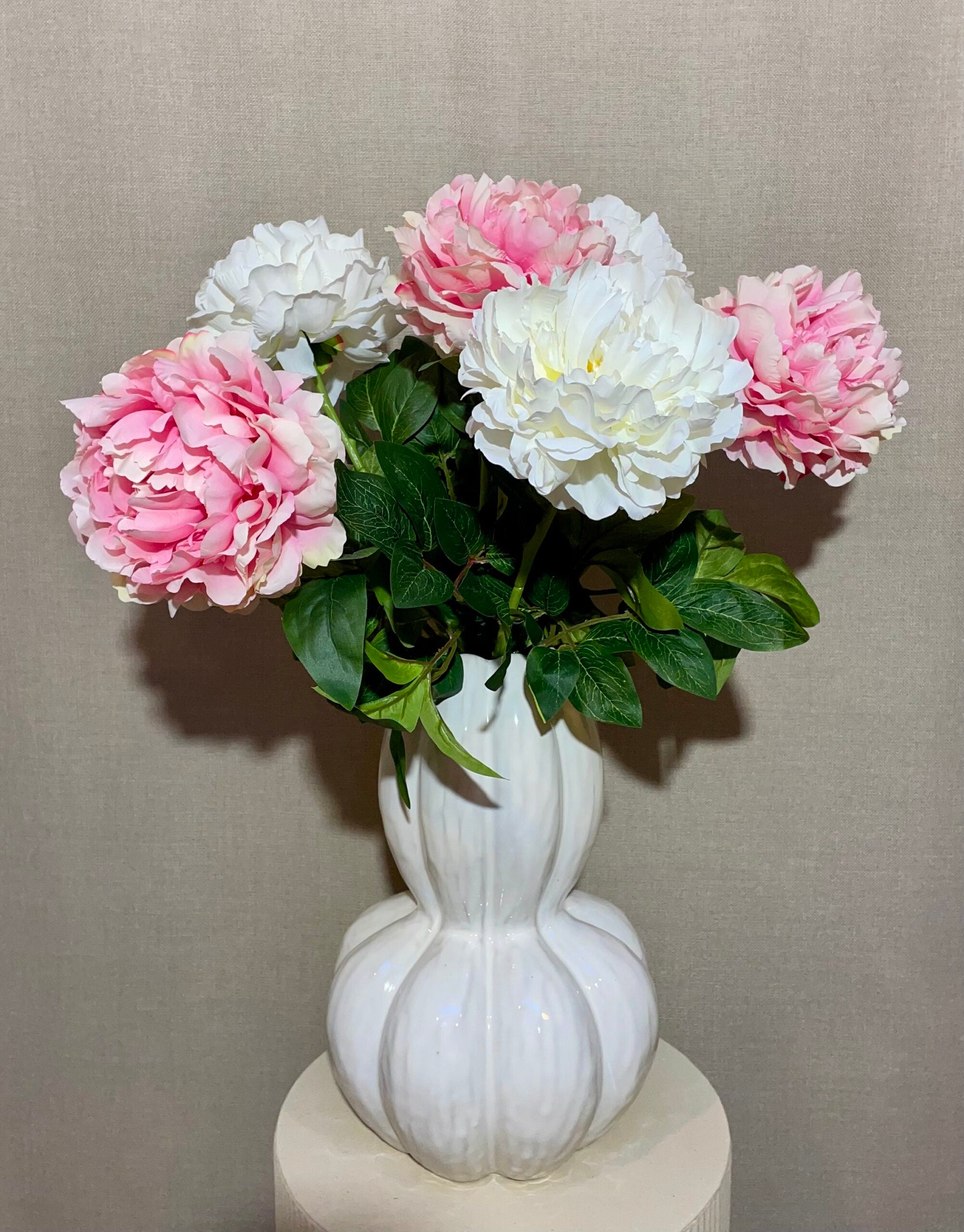 Buket med rosa og hvide kunstige peony blomster i hvid vase