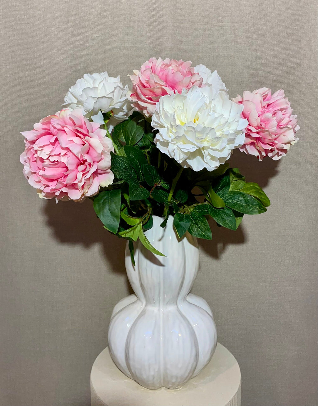 Buket med rosa og hvide kunstige peony blomster i hvid vase
