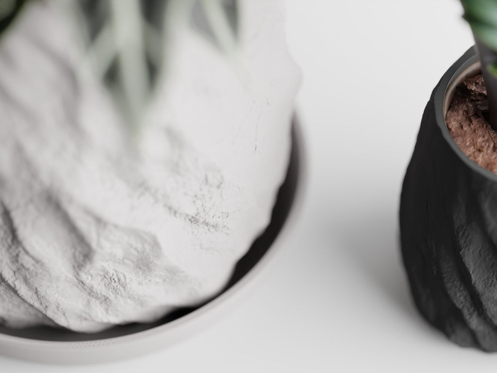 Mura urtepotte set oppefra med underskål og stenstruktur