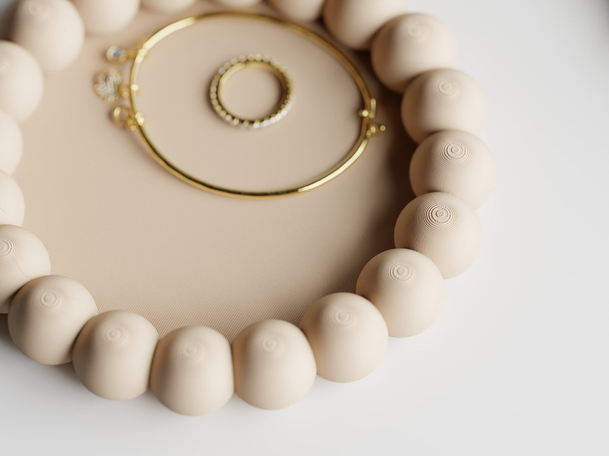 Nærbillede af Spheris rund smykkebakke i beige med armring og ring