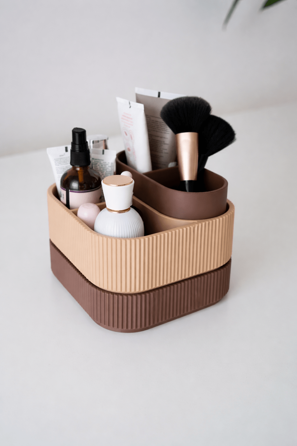 Stacksey stabelbar makeup organizer i varm brun og beige med lodrette ribber, fyldt med makeup-produkter og pensler