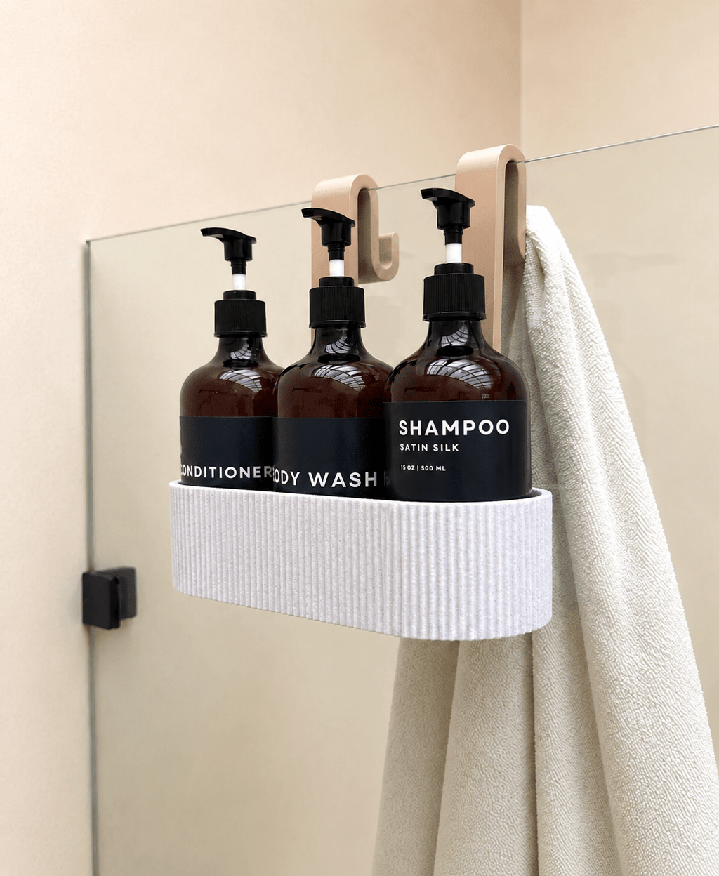 TAVO brusehylde i hvid hængt over glaspanel med shampoo, balsam og håndklæde – badeværelsestilbehør fra Homae