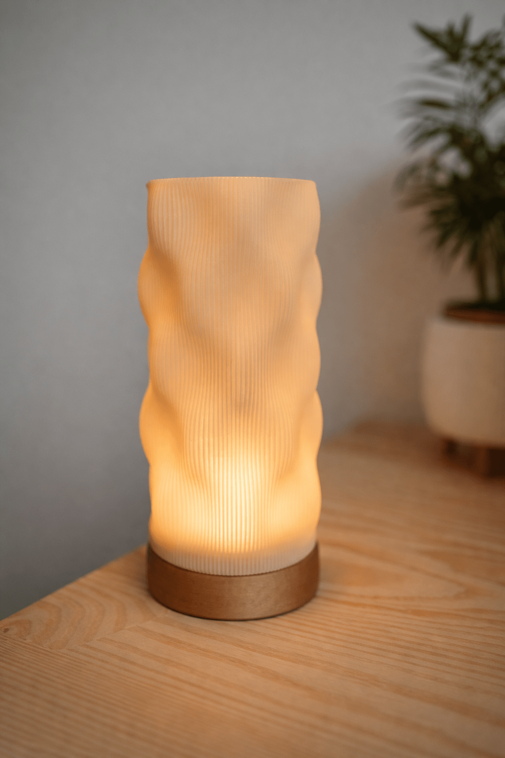 Wavia bordlampe slukket set fra siden – organisk skulpturel bølgeform med lodret ribstruktur i beige PLA